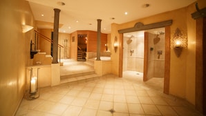 A spacious hotel lobby with a grand staircase, a reception area, and a spa entrance. - Gstaaderhof – Active & Relax Hotel  (Saanen)