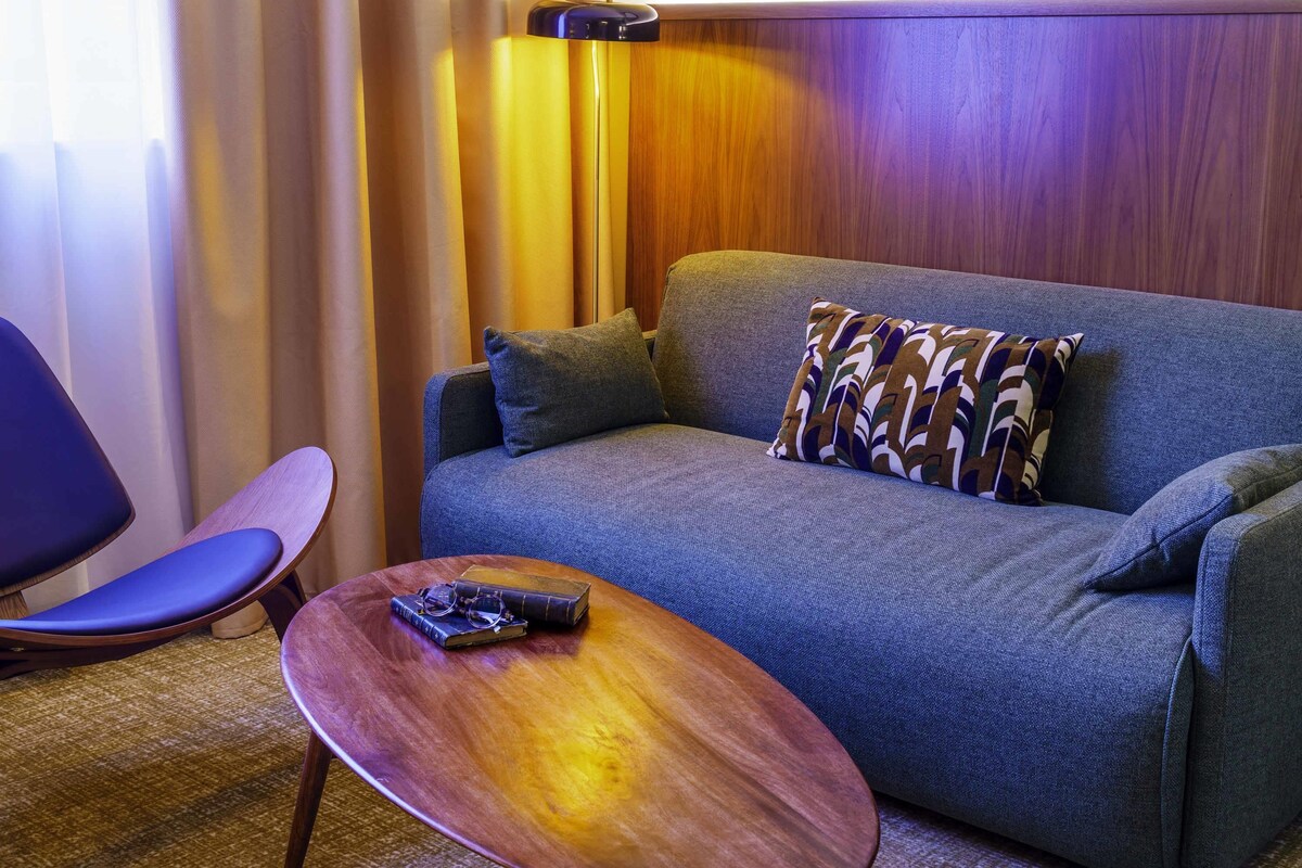 A modern room with a sofa, a wooden coffee table, and a chair.