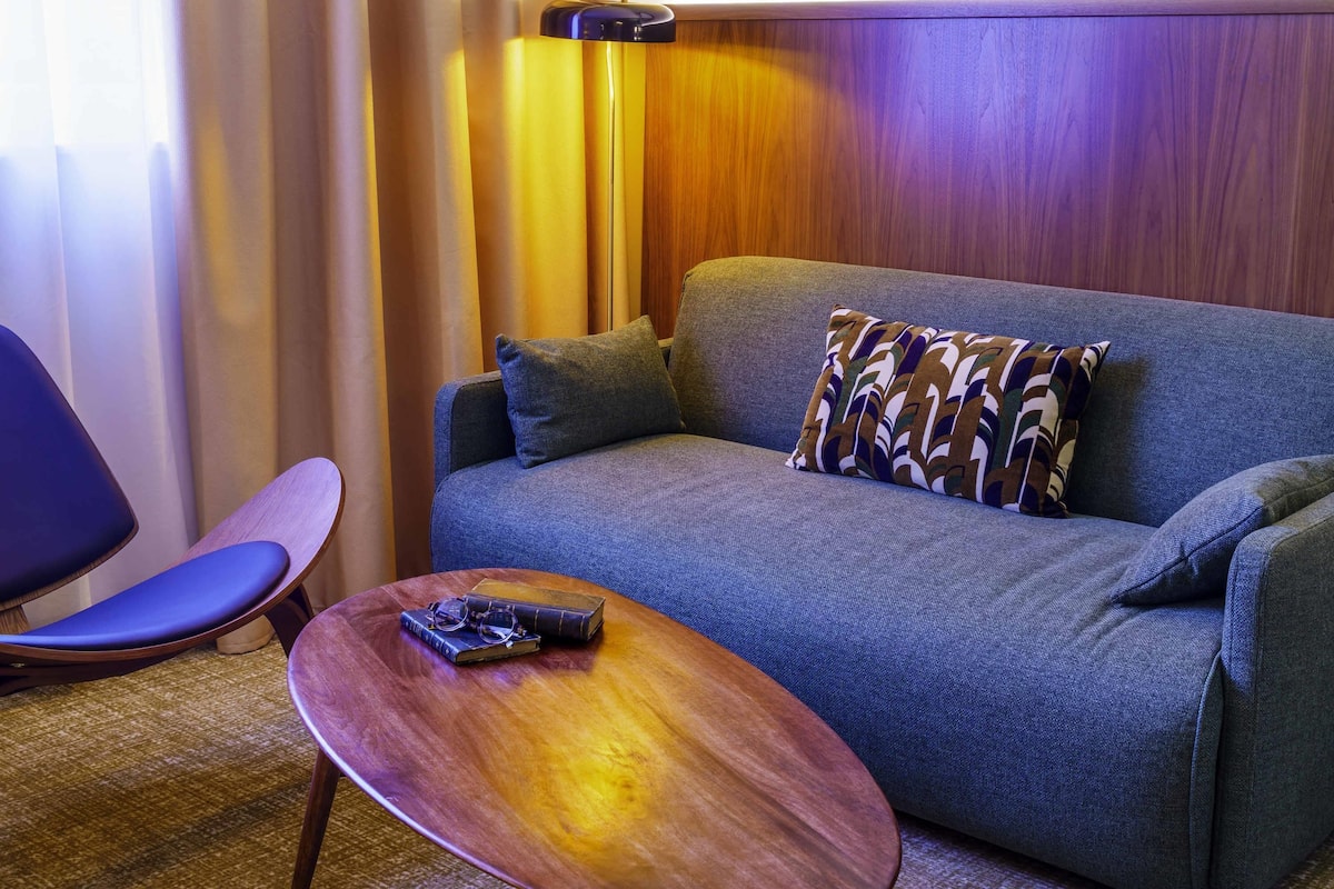A modern room with a sofa, a wooden coffee table, and a chair.