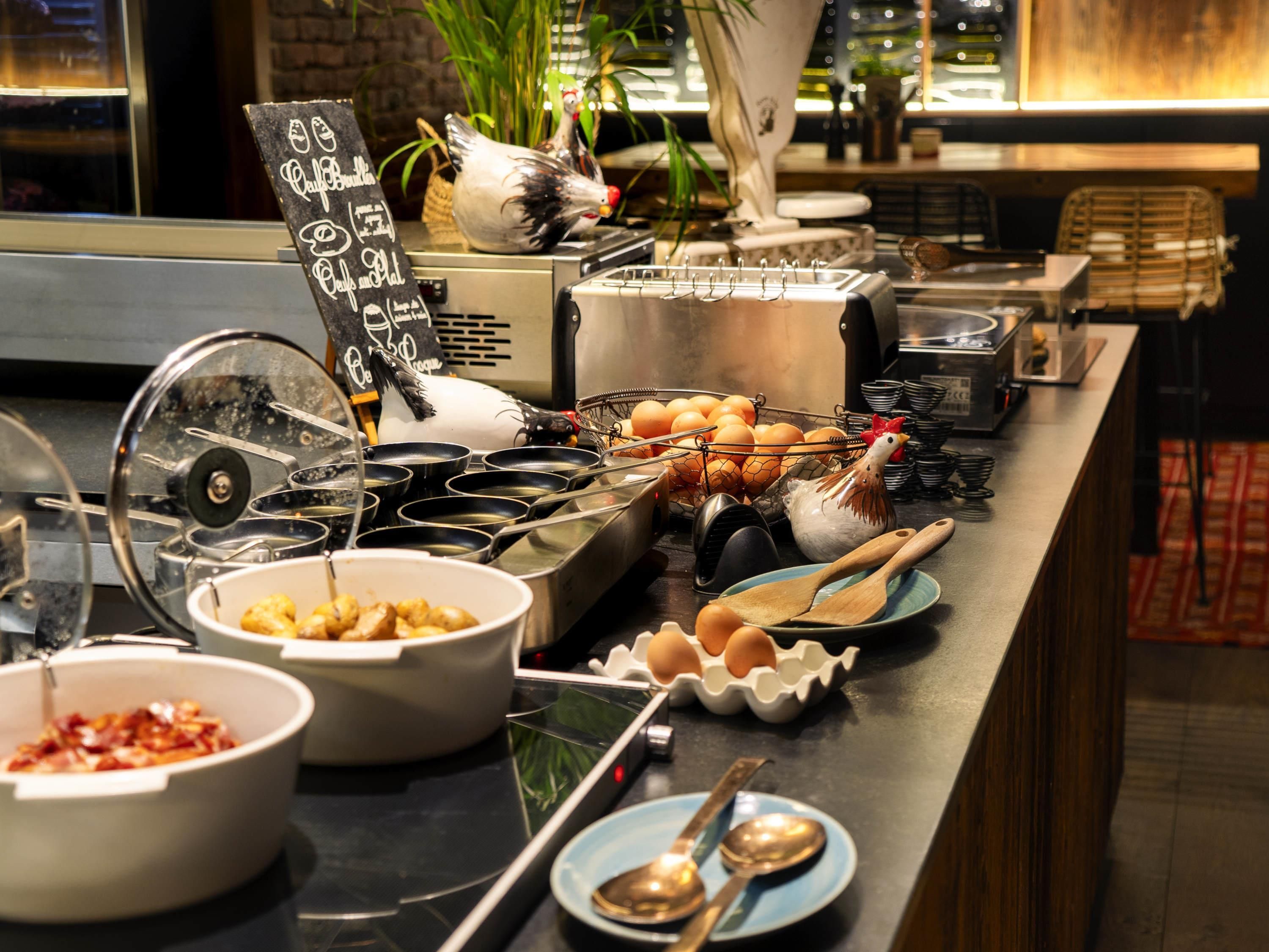 A buffet setup with various food items, utensils, and a chalkboard menu.