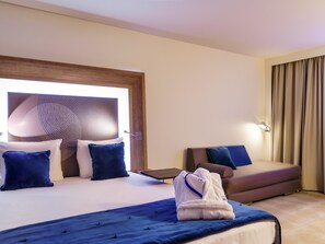 A hotel room with a bed, a chair, a desk, and a window with curtains. - Novotel Avignon Nord (Sorgues)