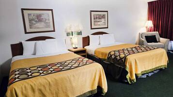 Une chambre d’hôtel avec deux lits, chacun recouvert d’une couvre-lit à motifs, une table de chevet avec une lampe et deux tableaux encadrés accrochés au mur.