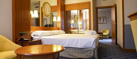 Una habitación de hotel con una cama, una mesita de noche, una lámpara y una silla.