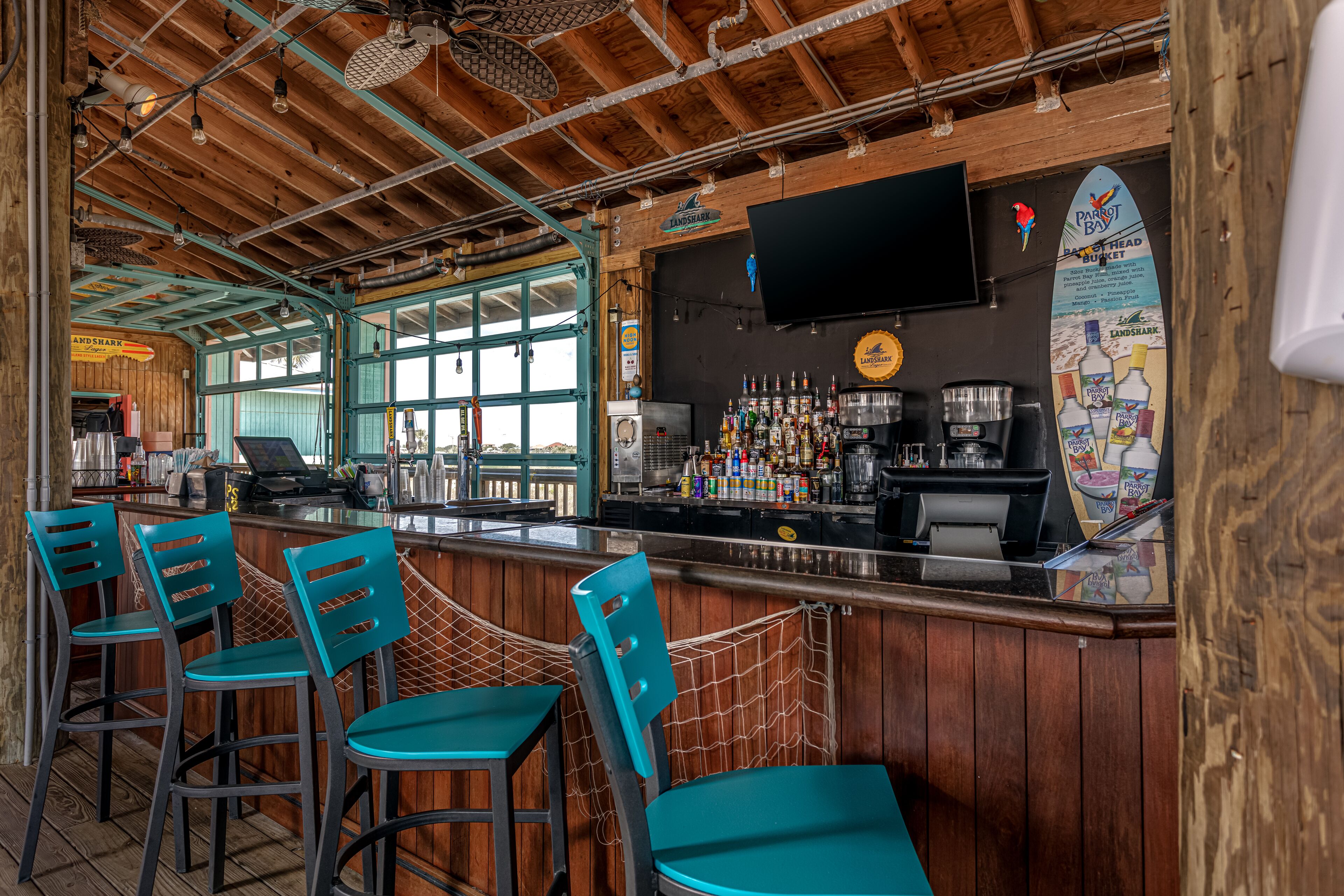 A bar with wooden interior, bar stools, and a counter with various bottles.