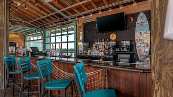 A bar with wooden interior, bar stools, and a counter with various bottles.