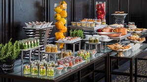 A buffet table with various food items and a decorative yellow bell pepper arrangement. - Hilton Vienna Plaza (Vienna)