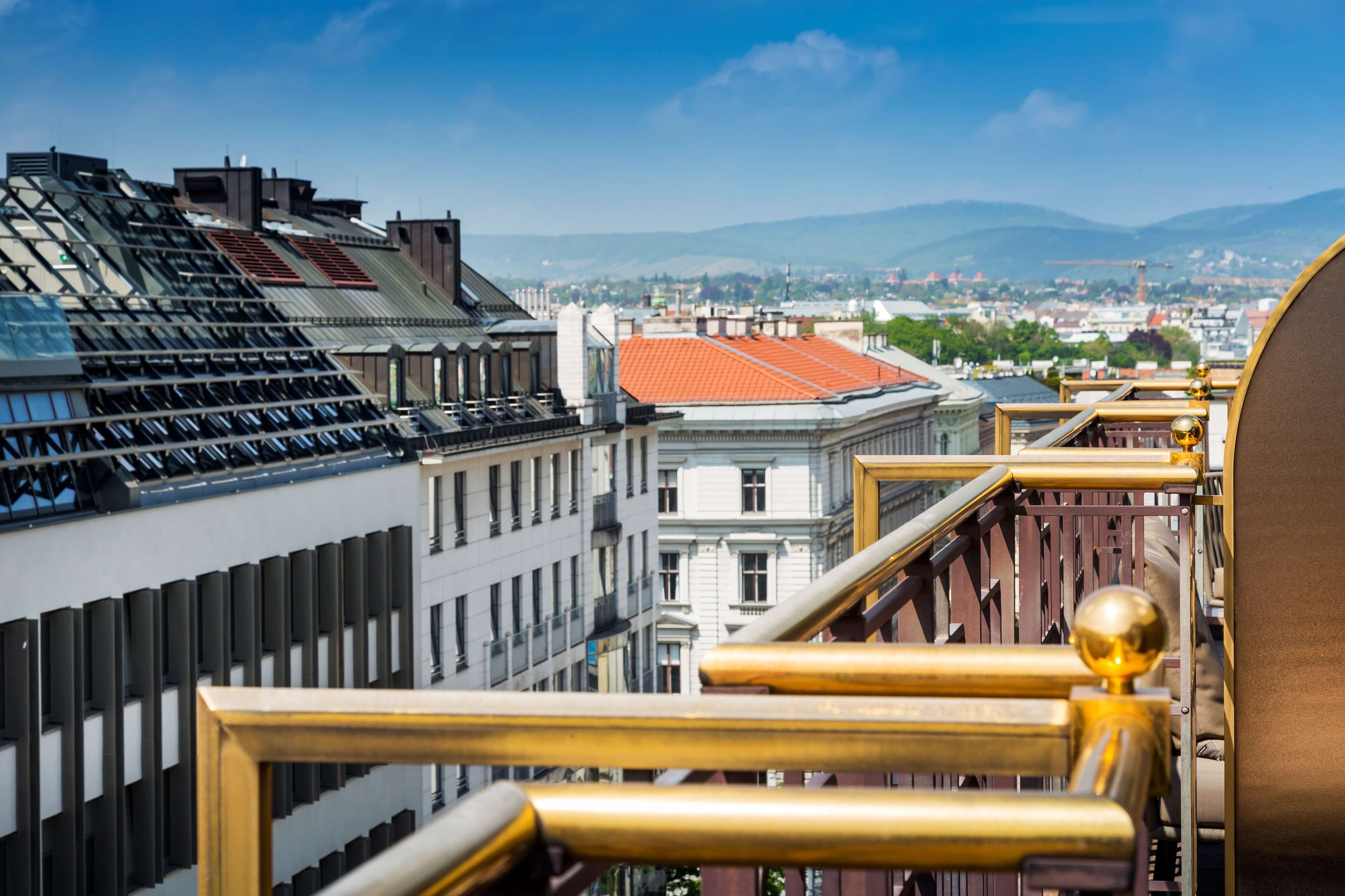 A high-rise building with a view of a cityscape and mountains in the distance.