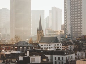 A cityscape with modern high-rise buildings and a historic church with a pointed spire.