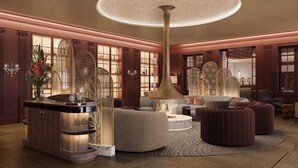 A luxurious lobby with a grand chandelier, ornate wooden paneling, and plush seating areas.
