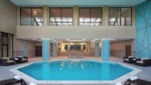 Una piscina interior con sillones de descanso y una zona de bar.