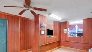 A room with wooden paneling, a ceiling fan, a television, and a window with a view. - Days Inn by Wyndham Newport (Newport)