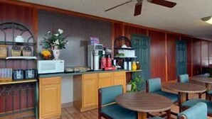 A cozy room with a kitchen area, a ceiling fan, and a seating area with chairs and a table. - Days Inn by Wyndham Newport (Newport)
