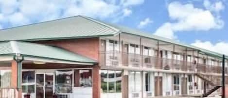 A two-story building with a flat roof and large windows.