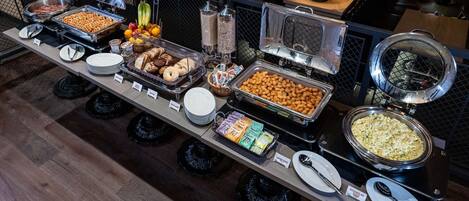 A buffet with various food items and condiments.