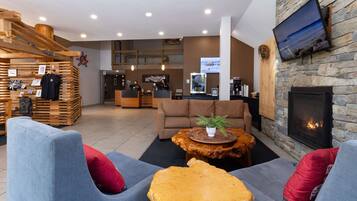 A modern lobby with a reception desk, seating area, and a stone fireplace.