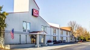 A two-story EconoLodge building with a flat roof, large windows, and a red and white color scheme.