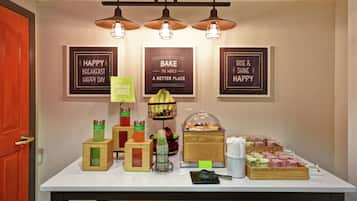 Disposição de buffet de café da manhã com diversas opções de alimentos e um espaço para café.