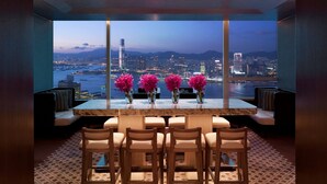 A modern dining area with a city view, a marble table, and six chairs. - Conrad Hong Kong (Hong Kong)