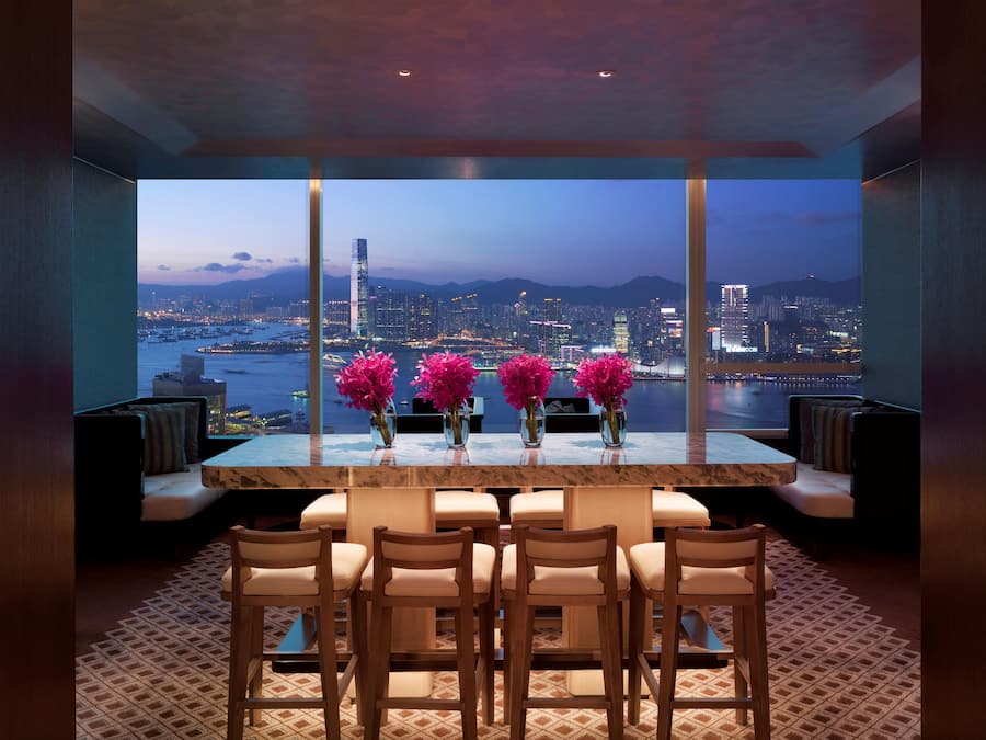 Un espace repas moderne offrant une vue panoramique sur la ville, avec une table en marbre et six chaises.