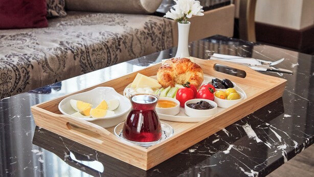 A tray with food items including eggs, cheese, bread, olives, and tomatoes on a marble table. - Konak Hotel Taksim (Istanbul)