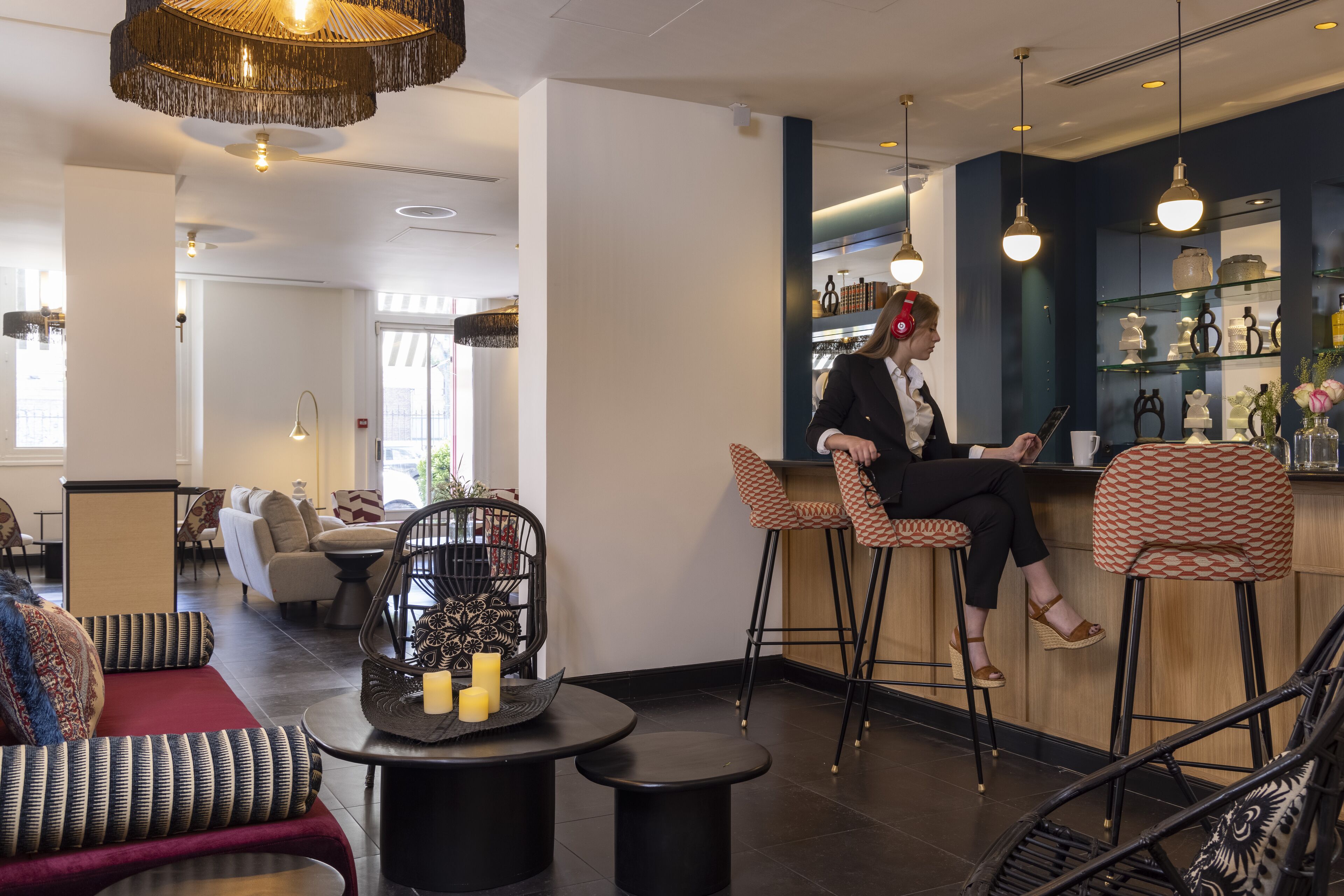 A modern bar area with high stools, a bar counter, and decorative lighting.