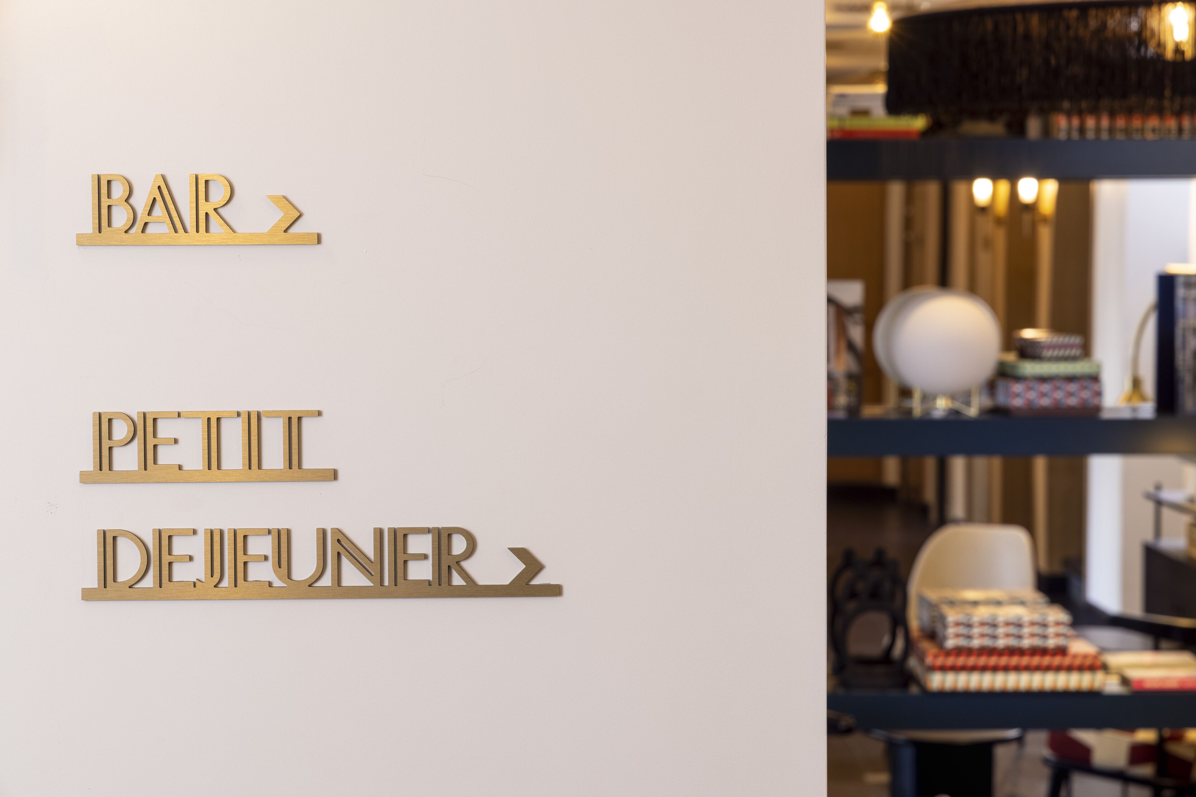 A wall with the words "BAR" and "PETIT DEJEUNER" in gold letters, indicating a bar and breakfast service.