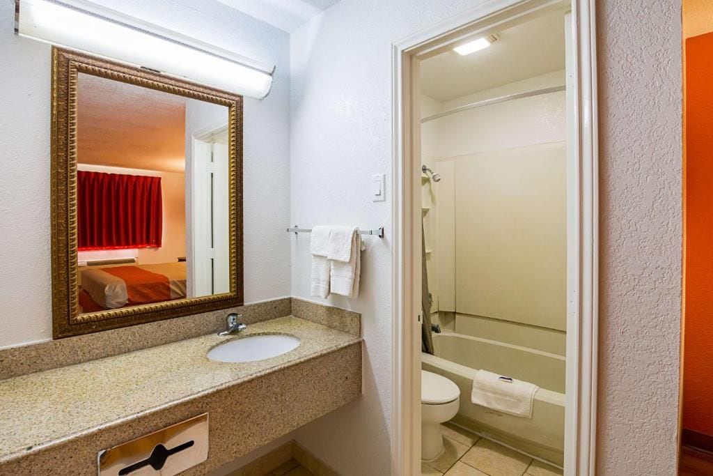 Ein Badezimmer mit Waschbecken, Spiegel und Duschbereich.