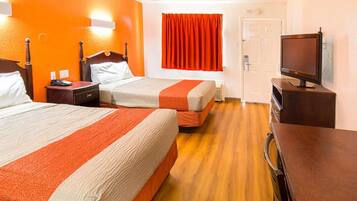Quarto de hotel com duas camas, uma televisão e uma porta.