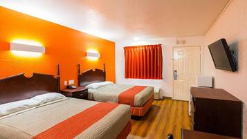 Une chambre d’hôtel avec deux lits, une télévision et un bureau.