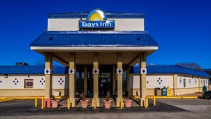A Days Inn with a blue roof, beige walls, and a sign above the entrance.