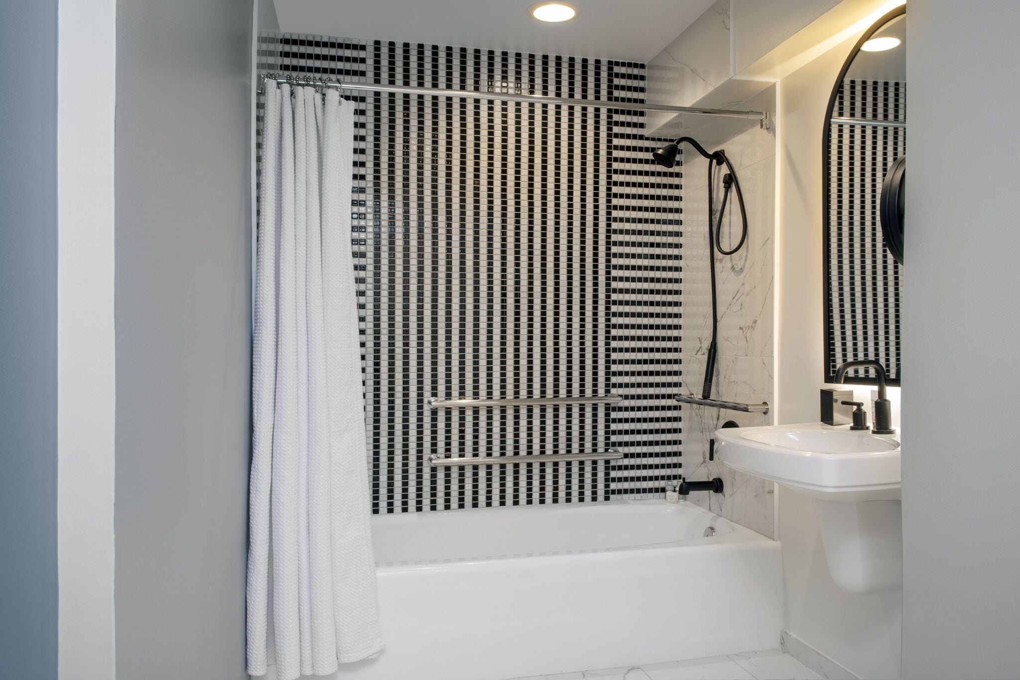Une salle de bain moderne avec une baignoire, une douche et un lavabo.