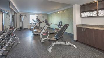 A gym with treadmills, elliptical machines, and free weights.