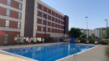 Una piscina al aire libre de temporada, sombrillas