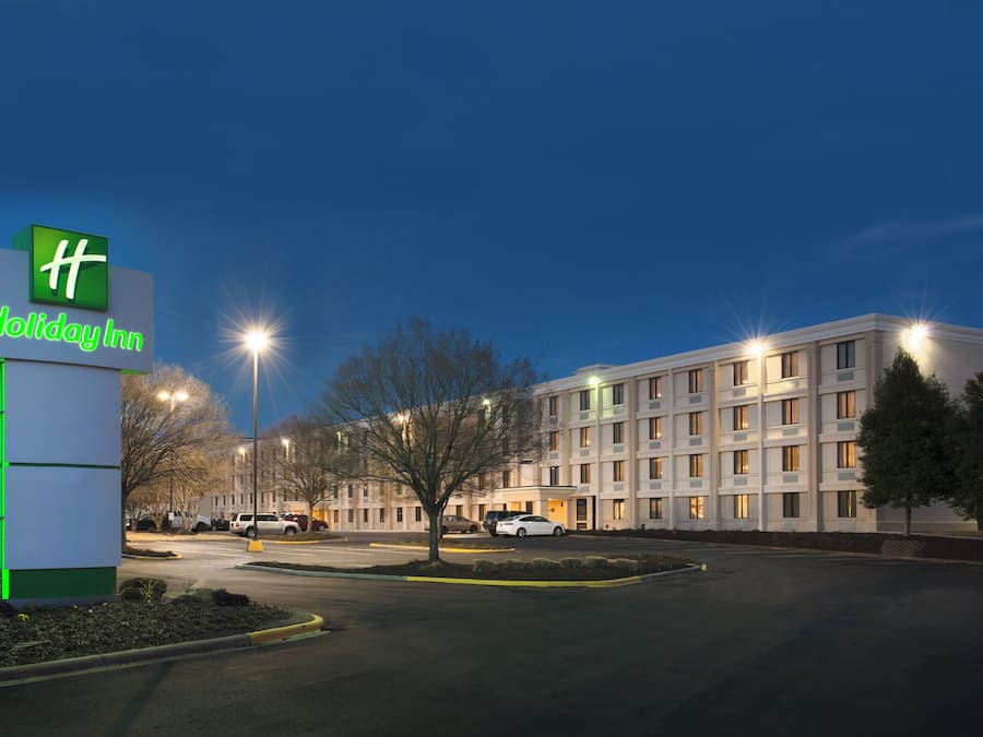 A Holiday Inn sign with a modern building in the background.