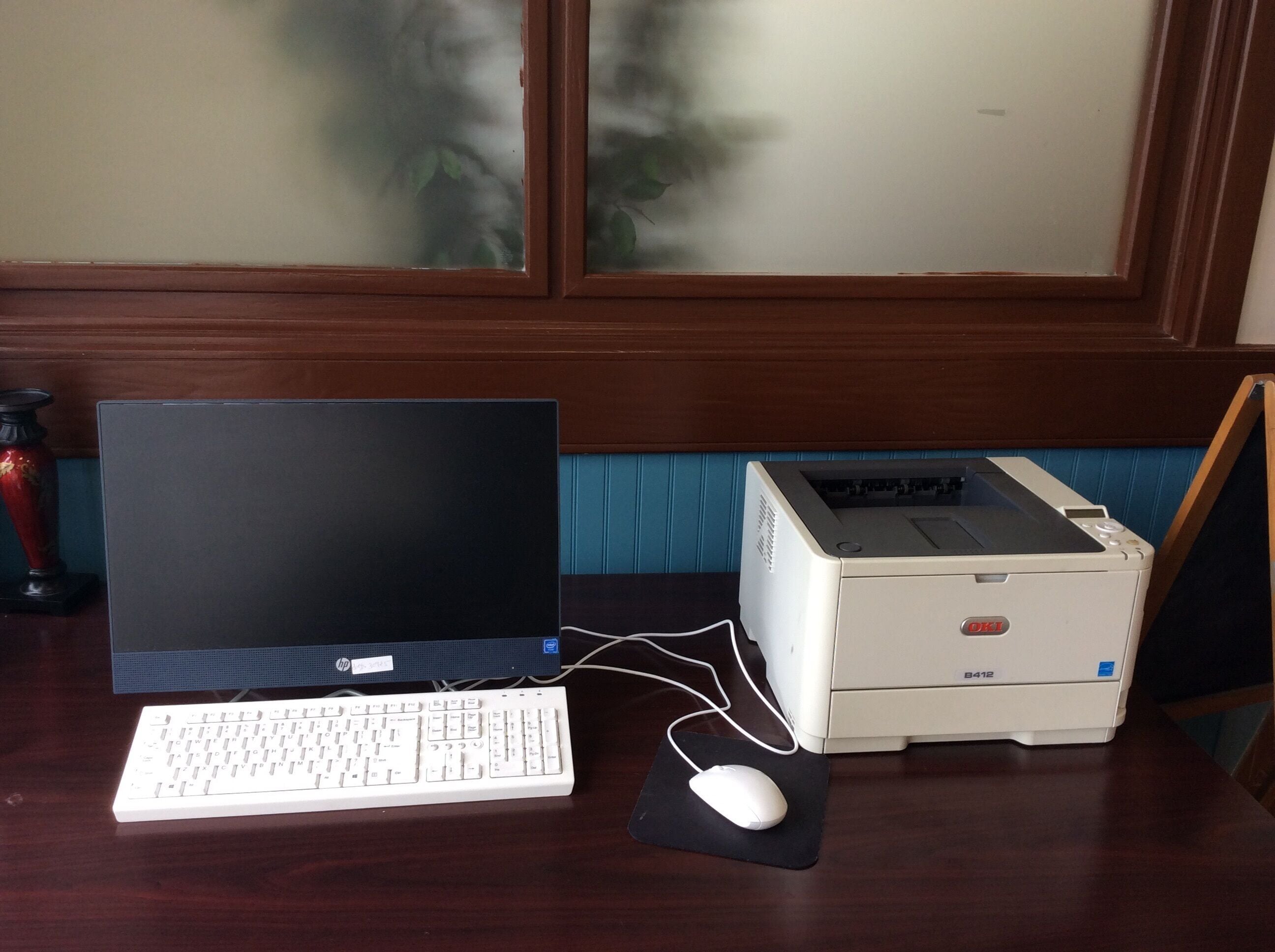 Una computadora de escritorio con teclado y ratón sobre un escritorio de madera.
