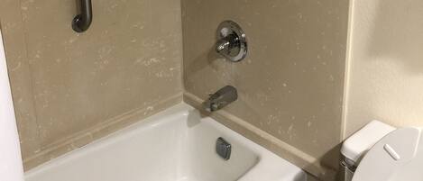 Un baño con bañera, ducha y retrete.