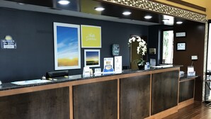Un mostrador de recepción con salpicadero de azulejos, cuadros enmarcados y un letrero que dice 'Hello Sunshine'.