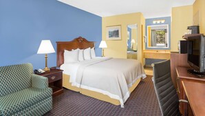 A hotel room with a bed, two bedside lamps, a TV, a desk, and a chair. - Days Inn by Wyndham Mocksville (Mocksville)