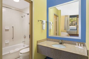 Bathroom features a bathtub, toilet, and granite sink with mirror.