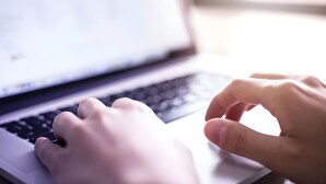 Un ordinateur portable avec un clavier et une main qui tape.