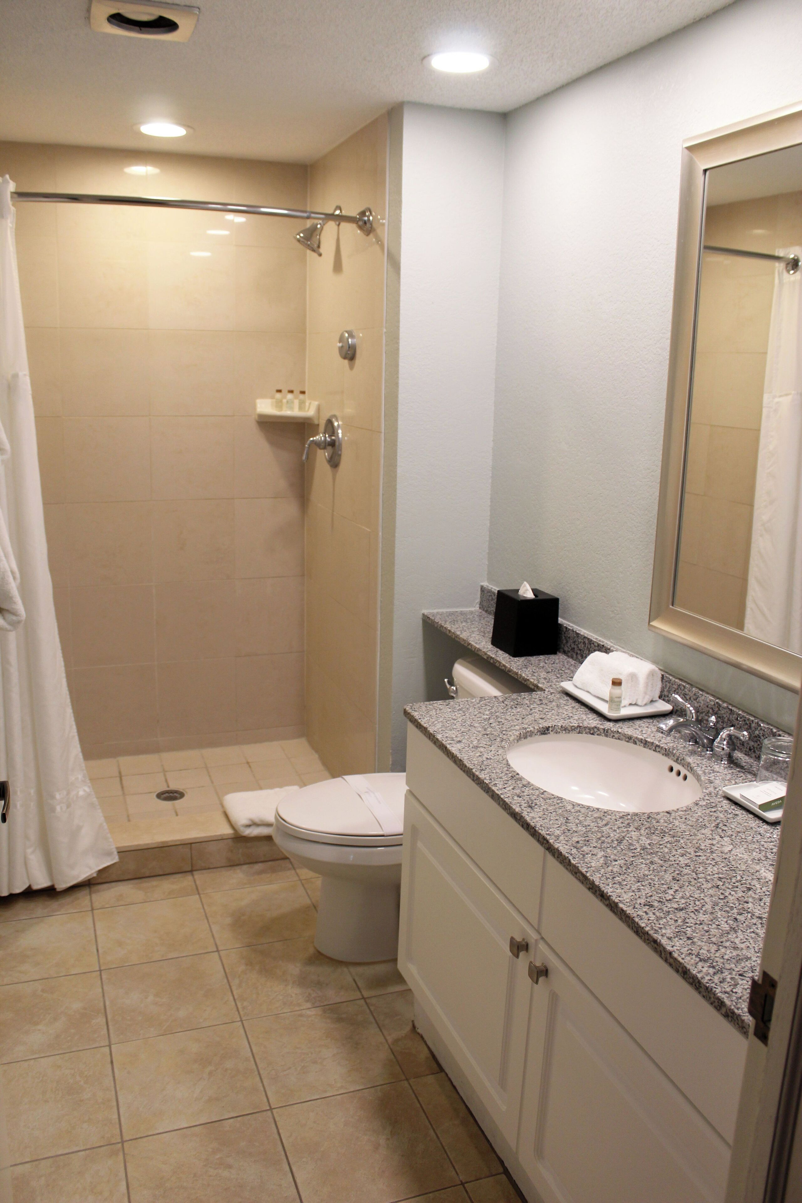 Un baño con ducha, inodoro y lavamanos.