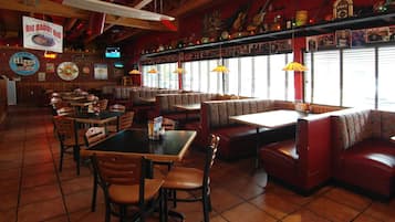 Un restaurante con cabinas, mesas y un reproductor de discos.