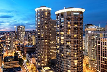 A modern hotel lobby with a bar area, seating arrangements, and large windows offering views. at The Westin Seattle