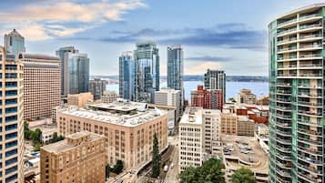 A high-rise hotel with multiple floors, a prominent corner location, and a view of the city skyline and water.