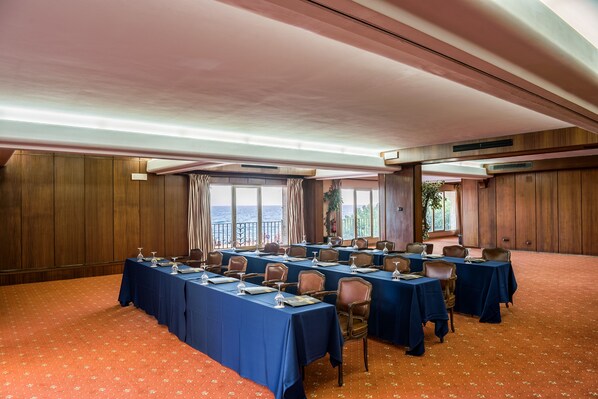 A conference room with long tables, chairs, and a view of the sea through large windows. - Rigat Park & Spa Hotel (Lloret de Mar)