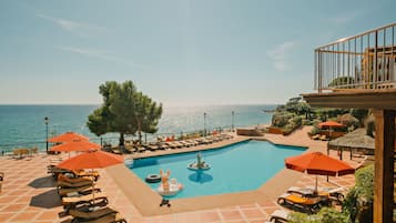 Piscine couverte, piscine extérieure, parasols de plage, chaises longues