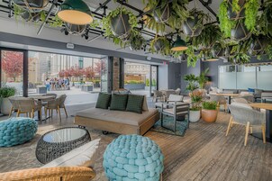 Een moderne lounge met zitplaatsen, een bank en hangplanten.