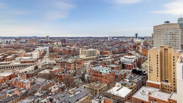 A cityscape with a mix of historic and modern buildings, a prominent red-brick structure, and a large, cylindrical building on the right.