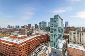 A high-rise building with a modern glass facade, surrounded by other buildings in an urban setting.