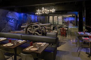 A restaurant with booths, tables, and a mural on the wall.